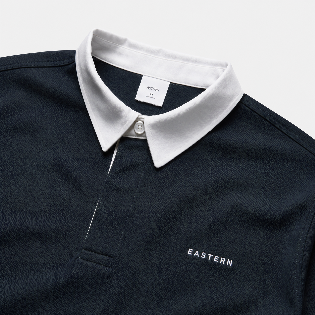 Close-up of EASTERN wordmark embroidery on Navy Opening Round Golf Polo