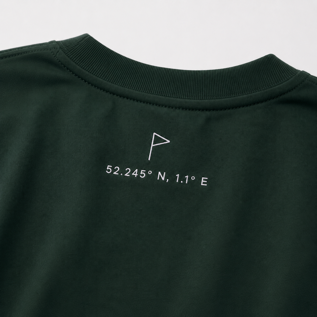 Close-up of Suffolk flag and coordinates embroidery on Pine Green Opening Round Tee
